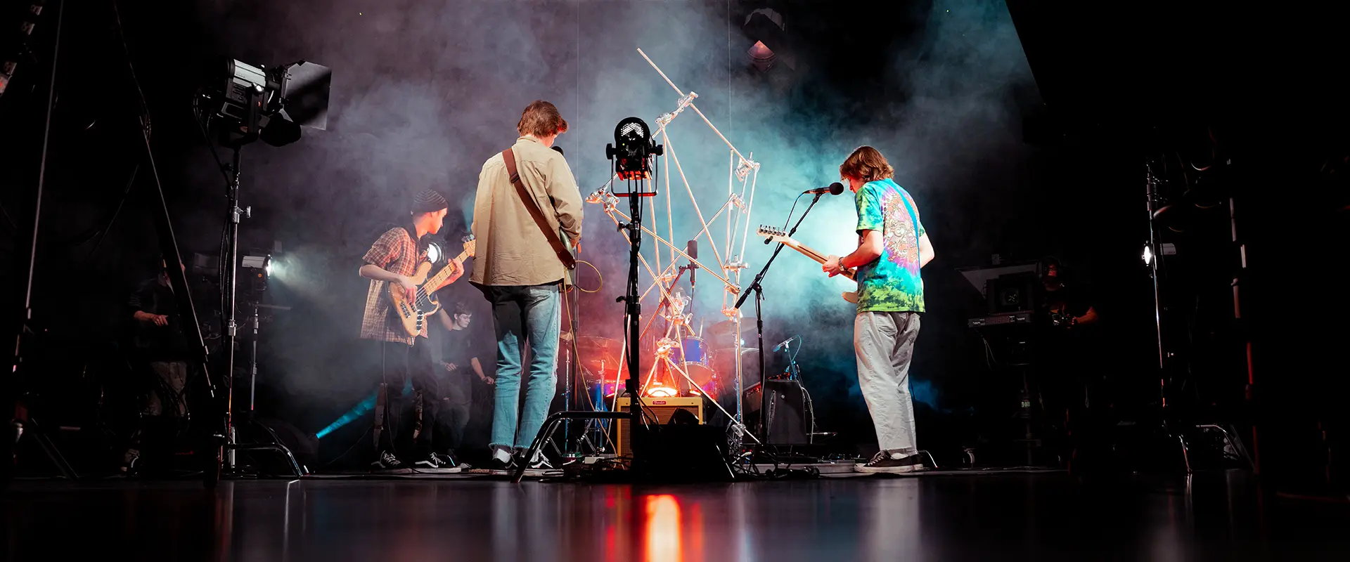 people standing in smoke machine, playing guitars